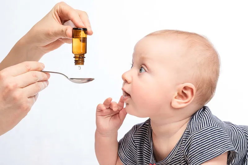 Administering liquid vitamin to infant