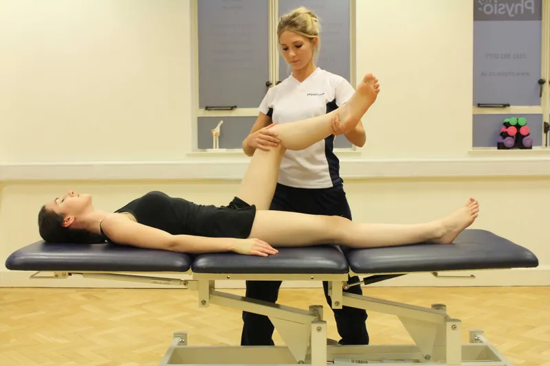 Physical therapist assists with leg raise exercise