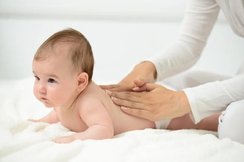 Infant receiving massage, cultural influence on development