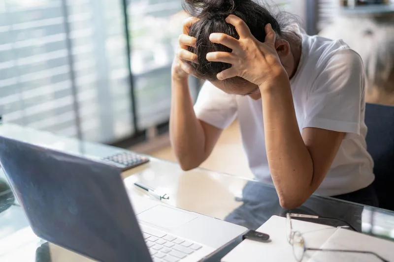 Person overwhelmed by stress at desk